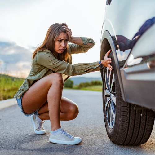 Woman worried about her flat tire