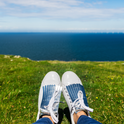 relaxed woman wearing sneakers overlooking ocean