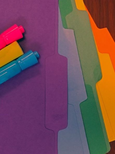 multi-coloured file folders and highlighters