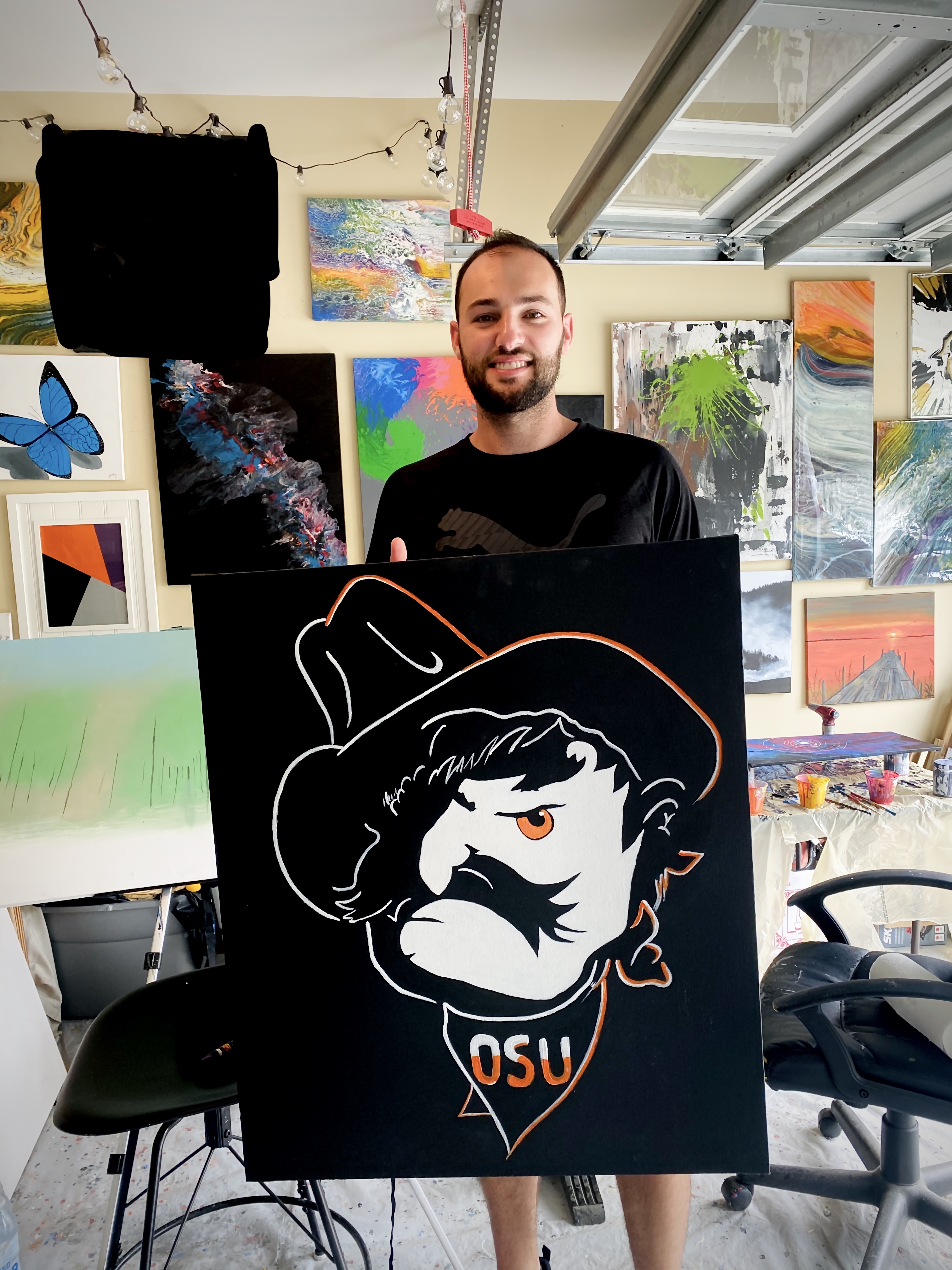 An artist holding a canvas art in his studio