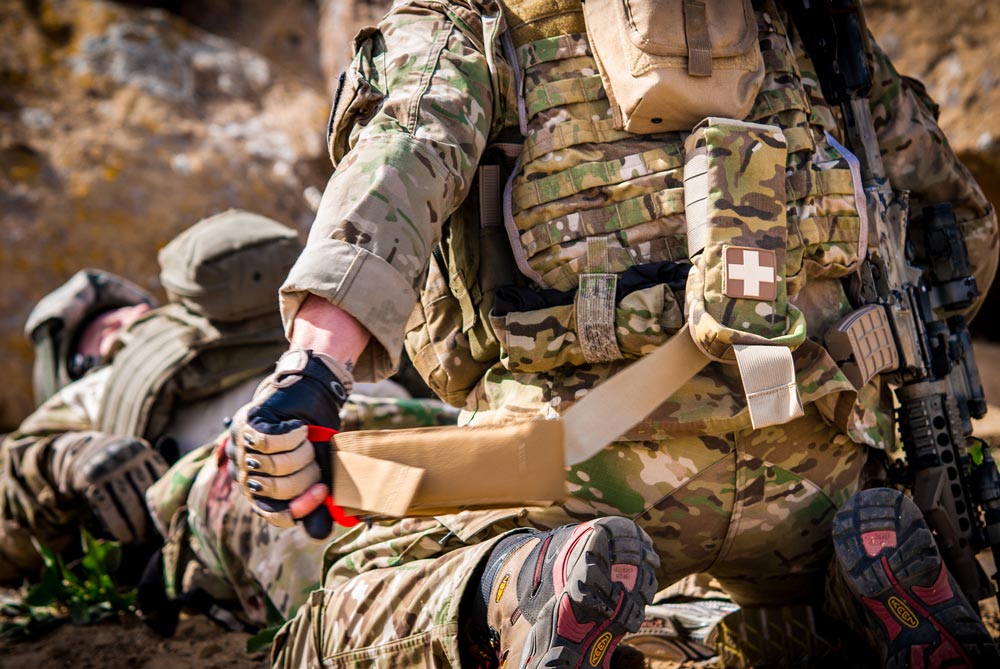 Military medical operator deploying first aid kit