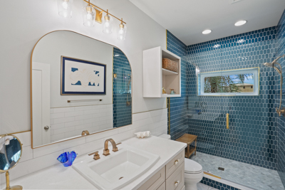 luxury bathroom with a blue tiled glass shower