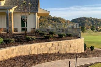 Curved stone block landscape retaining wall on golf course