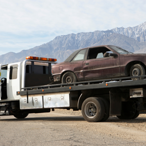 Old car being towed by a tow truck