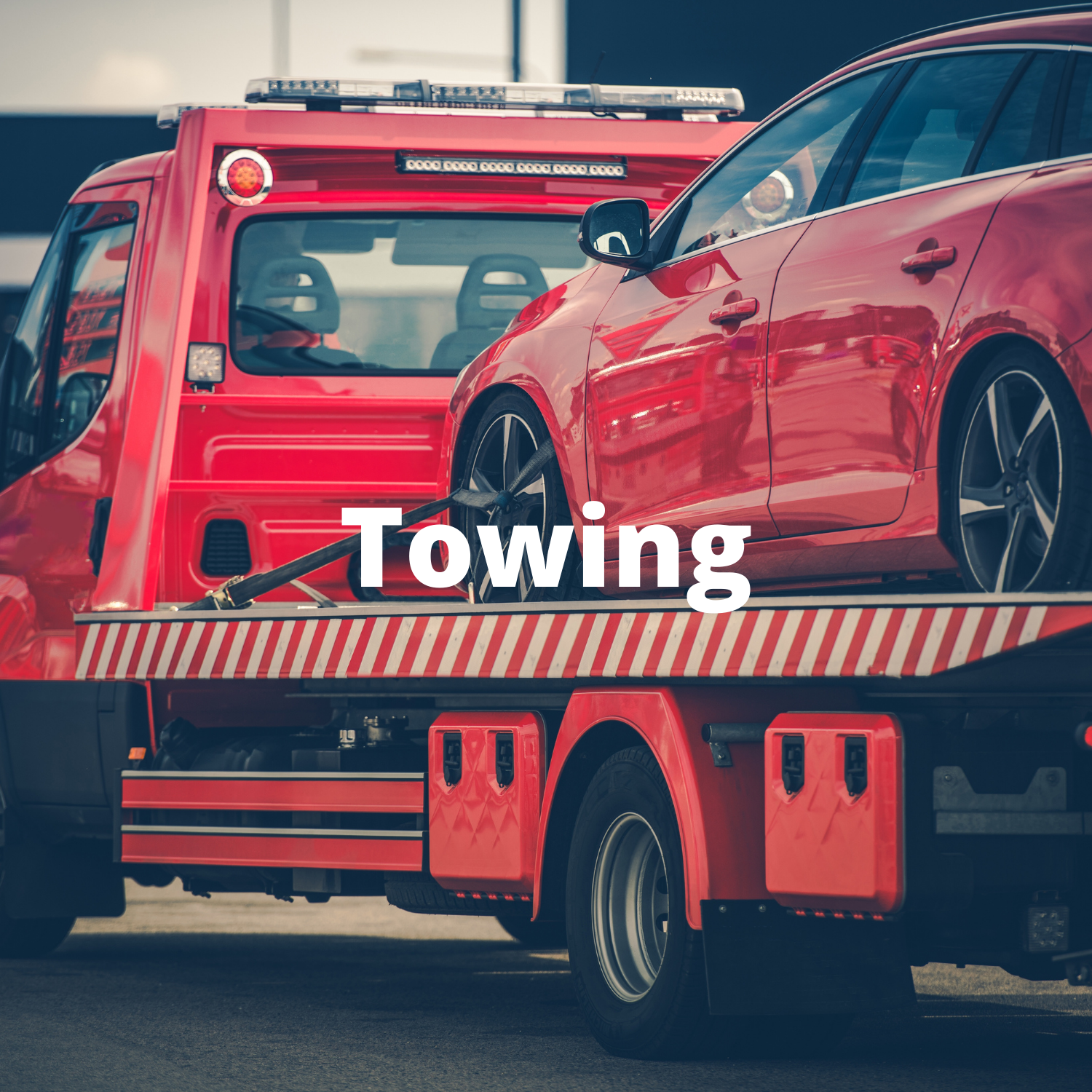 Red car being towed by a red tow truck