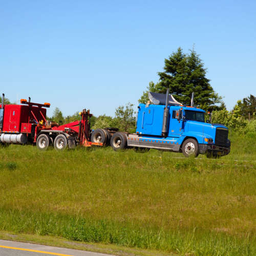 Blue semi-truck being towed