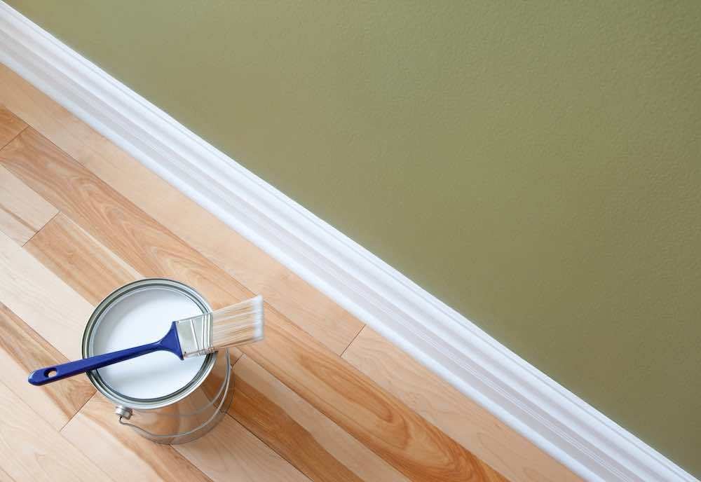 white painted baseboard trim and brush